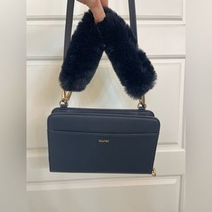 Navy Calpak travel wallet with two strap options